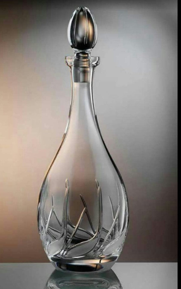 Glass decanter with decorative stopper on a reflective surface