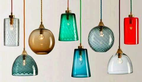 Colorful pendant lights with various glass shades hanging in a row.