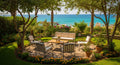 Outdoor patio area with chairs, table, and ocean view